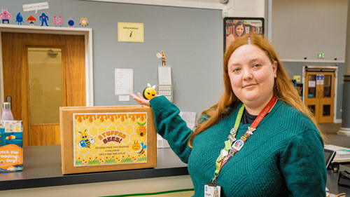 Megan Peoples from Woodside Library holding one of her crochet bees for the 2025 Summer Reading Challenge.