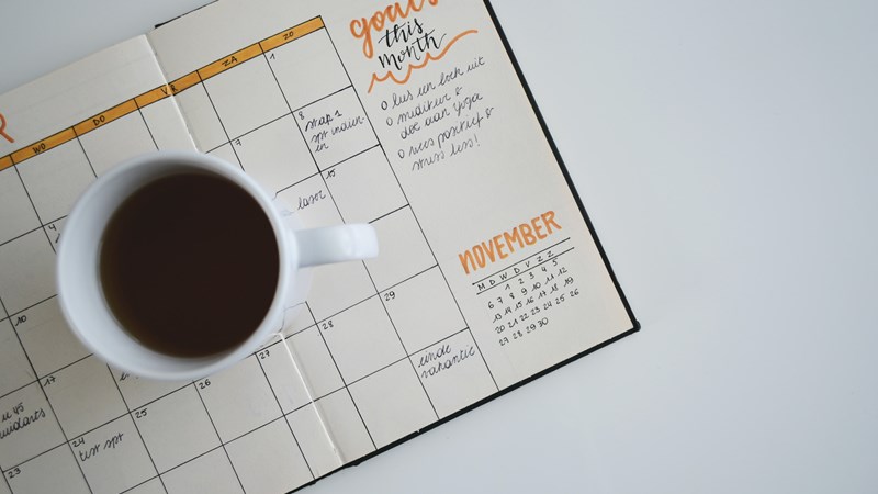 A mug of coffee sitting on a hand written calender/diary which says 'things to do'