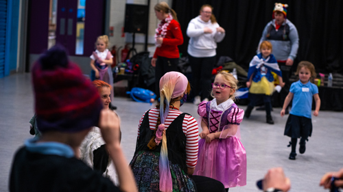 Young children get ready in costume to perform a play