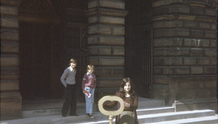 woman with large key stands in front of the People's Palace