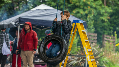 A young child playing on a tyre swing at Baltic Street Adventure Playground in Glasgow.