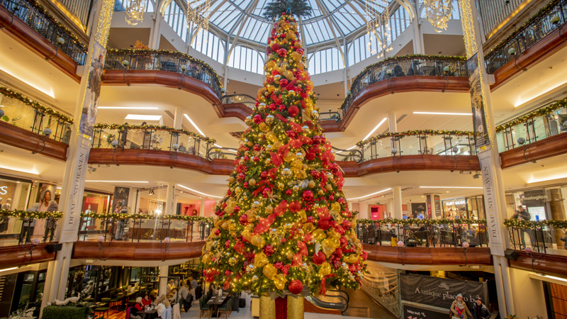 Close-up of tall Christmas tree with red and gold ornaments inside Princes Square shopping centre.