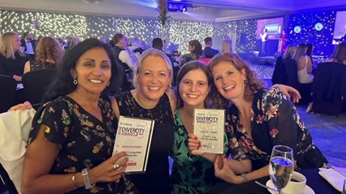A group of people from UCI smiling with their awards from The Herald Diversity Awards ceremony