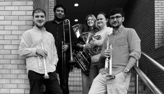 a black and white photo of 5 musicians stood outside RCS