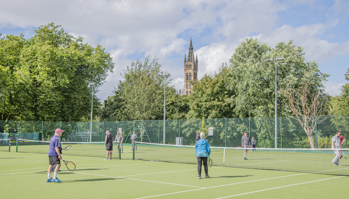Group of people playing tennis at Kelvingrove Tennis courts.