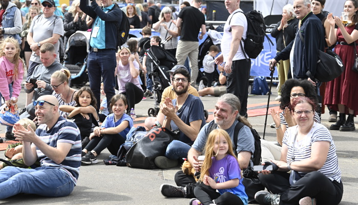 Crowds of people, representing different ages, ethnicities and genders, in the George Square fan zone during the 2023 UCI Cycling World Championships.