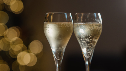 Two glasses of fizz on a sparkly table