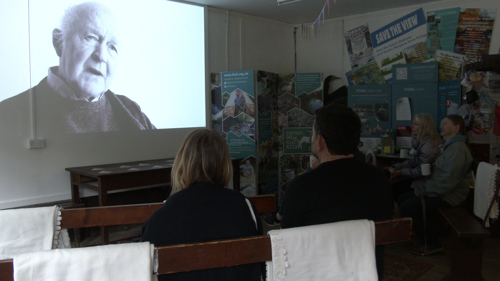 Two people watch a film in black and white.